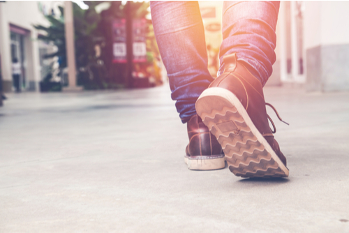 Close up of someone walking through a city in the sunlight